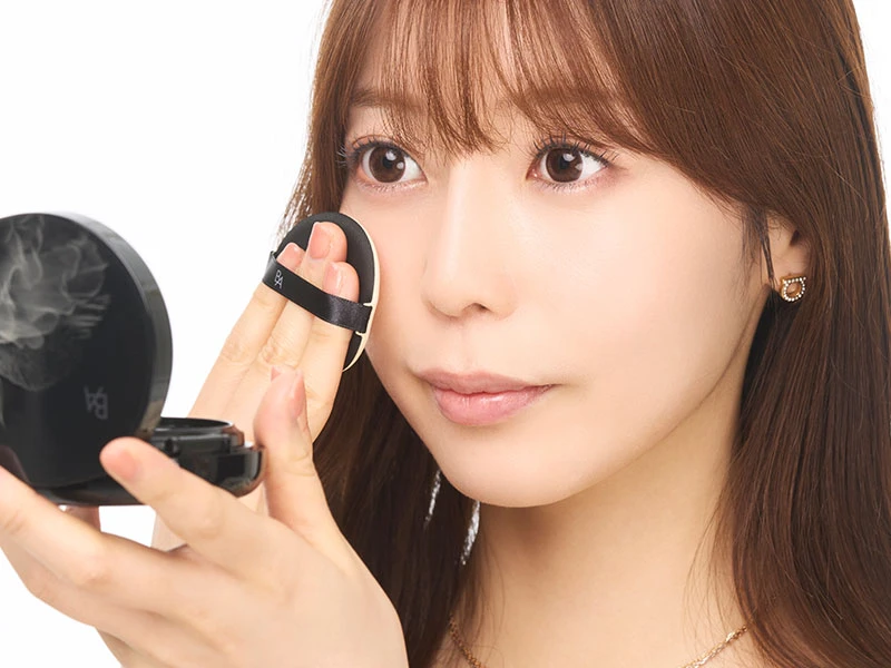 メイク直しのやり方のステップ3でファンデーションを少量ずつ肌につけている女性