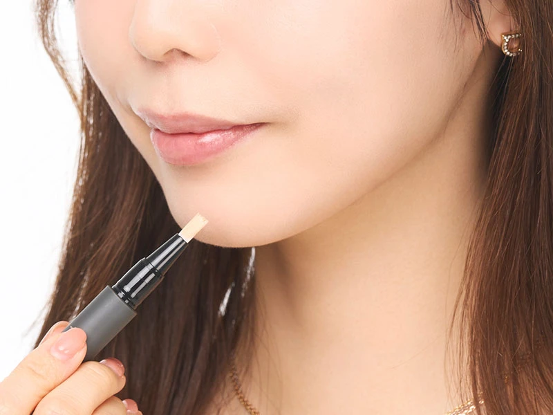 メイク直しのやり方のステップ4でコンシーラーで気になる部分をカバーしている女性