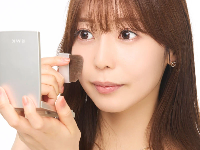 メイク直しのやり方のステップ5でフェイスパウダーで仕上げている女性