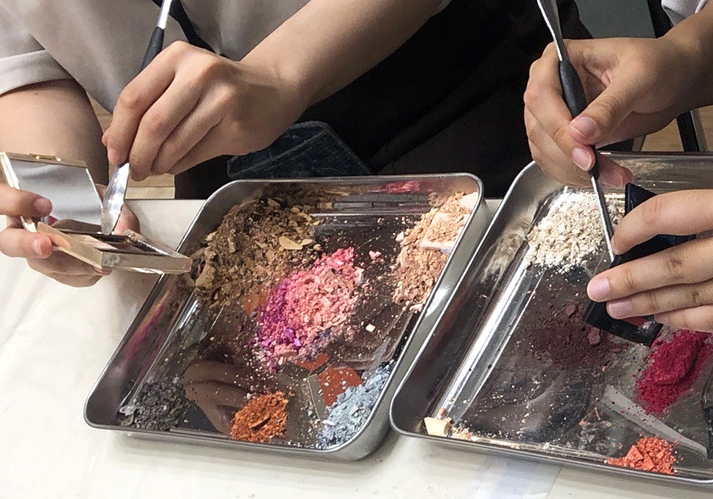 回収したコスメを手作業で掻き出している画像