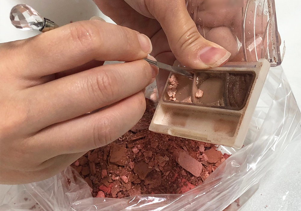 回収したコスメを手作業で掻き出している画像