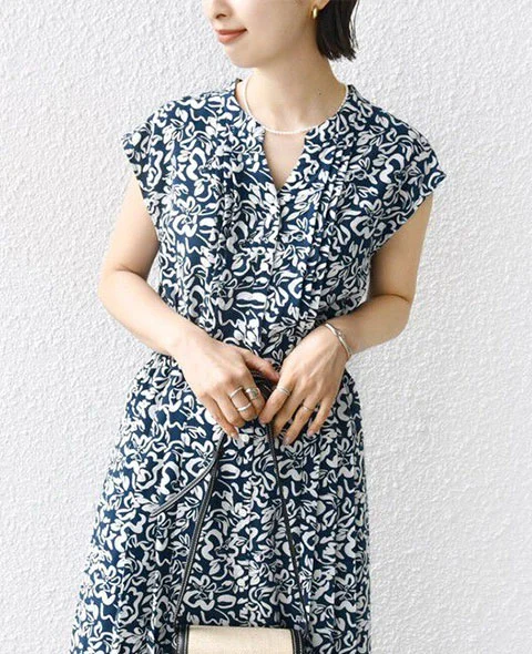 シップスのネイビーのドット花柄サイドプリーツフレンチスリーブワンピースを着用した女性