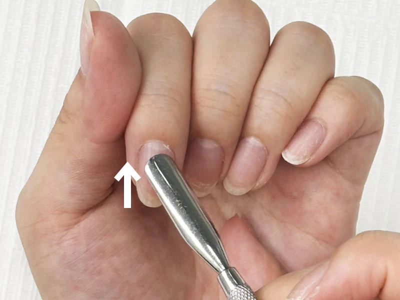セルフネイルのやり方の工程でキューティクルプッシャーで甘皮を押し上げている様子