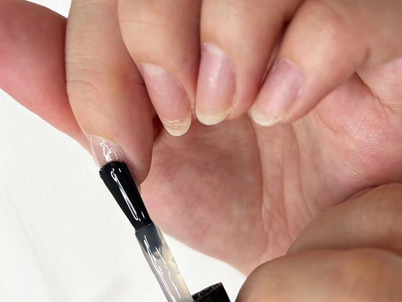 セルフネイルのやり方の工程で爪のサイドのラインを塗っている様子