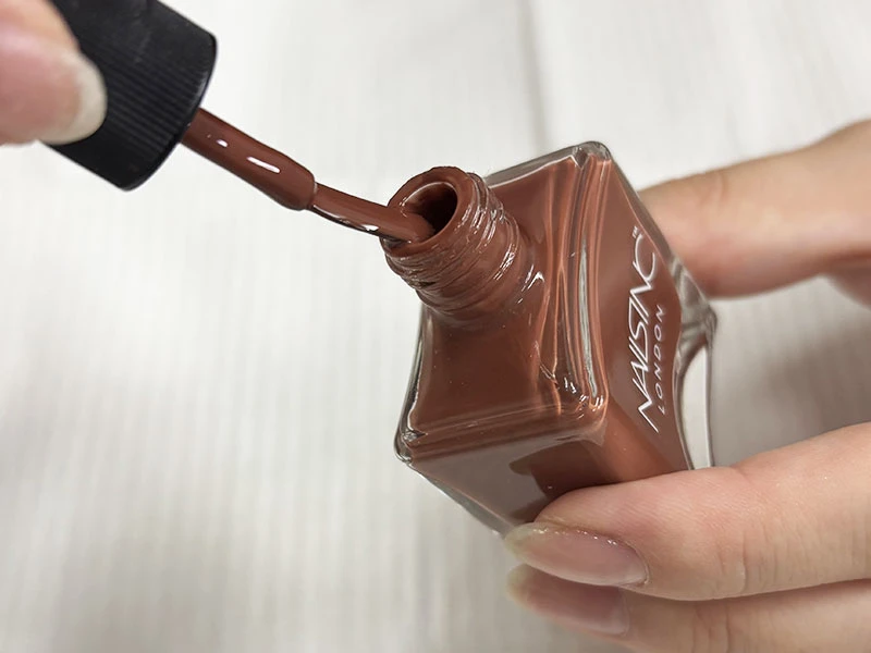 セルフネイルのやり方の工程でボトルの口で余分なポリッシュを落としている様子