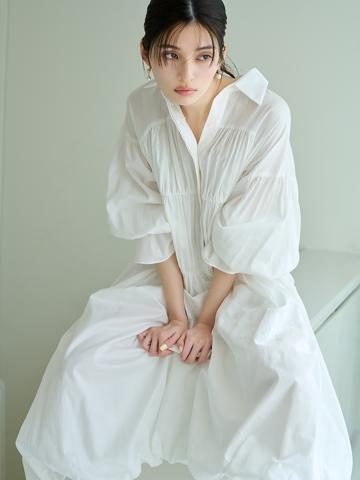 スナイデルのホワイトのコットンギャザーバルーンシャツワンピースを着用した女性